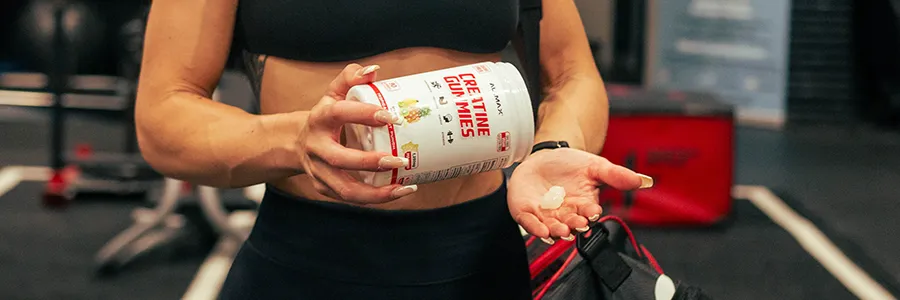 Fitness woman eating creatine gummies in gym as a sports nutrition gummy format