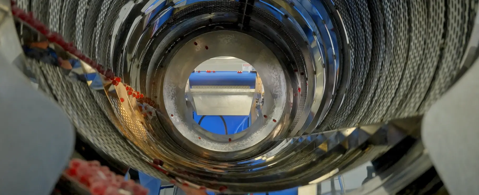 Gummies tumbling inside a coating drum during production