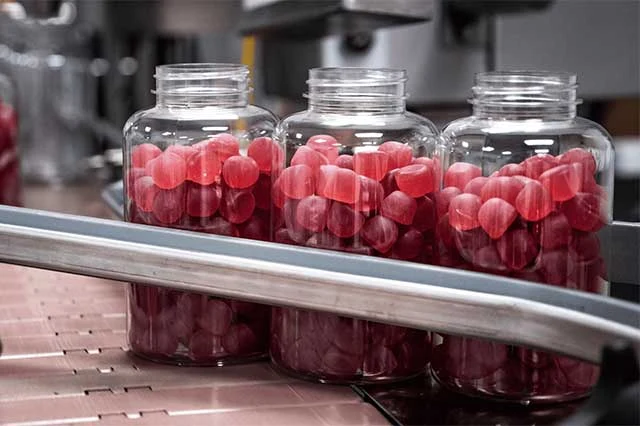 Gummy sample jars moving along a production line